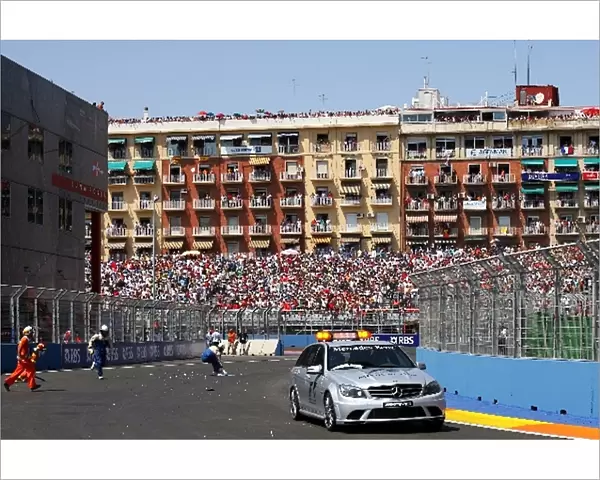 Formula One World Championship: The medical car passes marshals clearing the circuit of debris