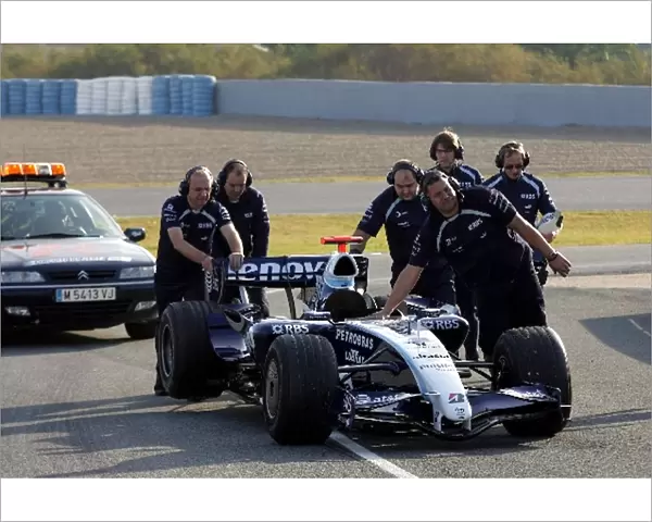 Formula One Testing: Williams mechanics collect the car of Nico Rosberg Williams FW29 after he stopped at the pitlane entry