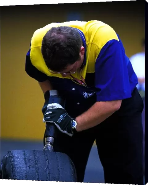 Formula One World Championship: A Michelin tyre technician cuts grooves in a tyre
