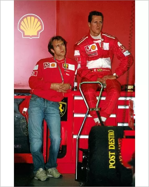 Formula One World Championship: Luca Badoer Ferrari Test Driver and Michael Schumacher in the pit garage