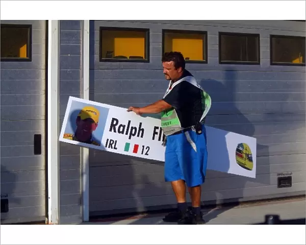 Formula One World Championship: A pitlane marshal replaces the garage name board of Ralph Firman Jnr Jordan with that of his replacement Zsolt