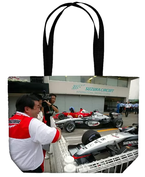 Formula One World Championship: Shigeo Watanabe President & CEO Bridgestone Corporation looks into parc ferme at the end of the race