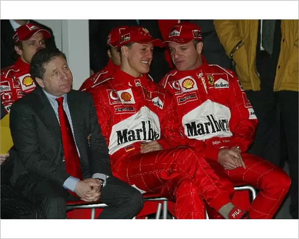 Formula One World Championship: L-R; Jean Todt, Michael Schumacher and team mate Rubens Barrichello watch the launch of the new Ferrari F2003-GA