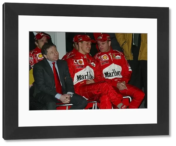 Formula One World Championship: L-R; Jean Todt, Michael Schumacher and team mate Rubens Barrichello watch the launch of the new Ferrari F2003-GA