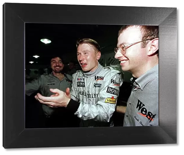 1998 BRAZILIAN GP. Mika Hakkinen, McLaren Mercedes, celebrates with his mechanics after securing his second successive pole position this year. Heading his team mate, David Coulthard into 2nd on the grid for the race in Sau Paulo. Photo: LAT