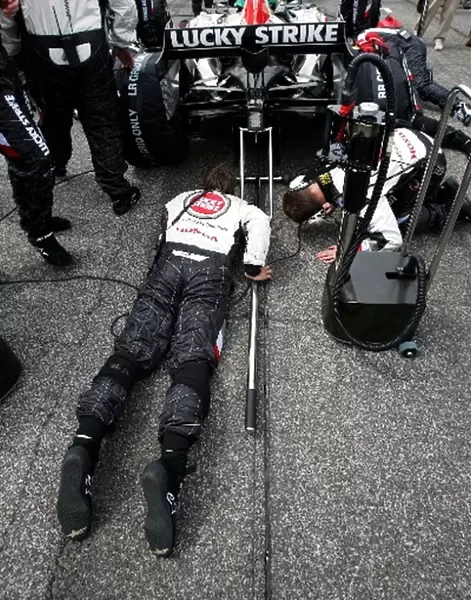 Formula One World Championship: BAR mechanics inspect the car of Jenson Button on the grid