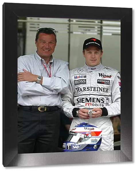 2003 Spanish Grand Prix - Sunday Race, Barcelona, Spain. 4th May 2003. Kimi Raikkonen, Team McLaren Mercedes MP4 / 17D, is presented with the new TAG Heuer link watch to commemorate his first Formula One win in the 2003 Malaysian Grand Prix by