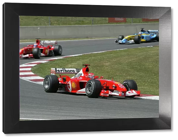 2003 Spanish Grand Prix - Sunday Race, Barcelona, Spain. 4th May 2003. Michael Schumacher, Ferrari F2003 GA, leads Rubens Barrichello, Ferrari F2003 GA, and Fernando Alonso, Renault R23, action. World Copyright LAT Photographic