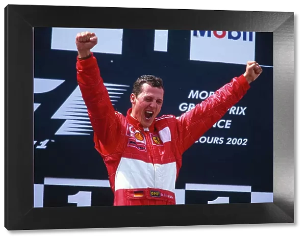 2002 French Grand Prix. Magny-Cours, France. 19-21 April 2002. Michael Schumacher (Ferrari) celebrates his 1st position and record equalling 5th formula one drivers World Championship on the podium. Ref-02 FRA 41. World Copyright - LAT Photographic