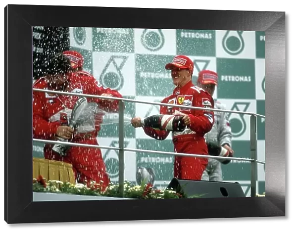 2001 Malaysian Grand Prix Sepang, Kuala Lumpur, Malaysia. 16th - 18th March 2001 Michael Schumacher, Ferrari, celbrates win 6 out of 6 as he sprays Ross Brawn with champagne. - podium. World Copyright: Steven Tee / LAT Photographic ref