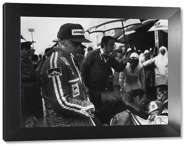 1976 Japanes Grand Prix: Niki Lauda looks on at team mate Clay Regazzoni, in the pits, portrait