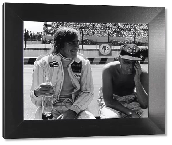 1979 Argentinian Grand Prix: James Hunt, retired, shares a joke with Niki Lauda, retired, in the pits, portrait