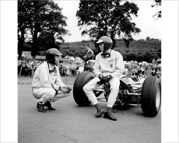 Spa-Francorchamps, Belgium: Jim Clark has a chat with Dan Gurney whilst sitting on his Lotus 25