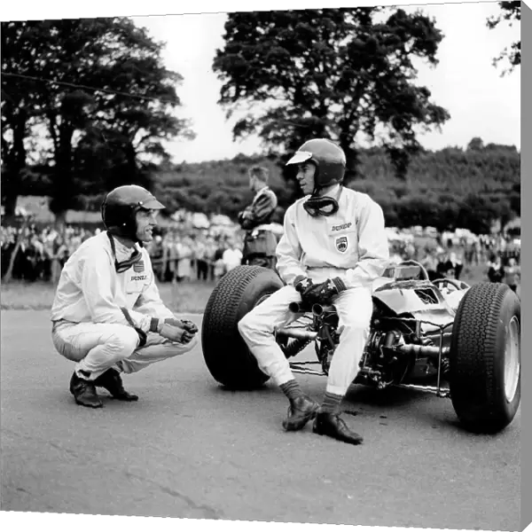 Spa-Francorchamps, Belgium: Jim Clark has a chat with Dan Gurney whilst sitting on his Lotus 25
