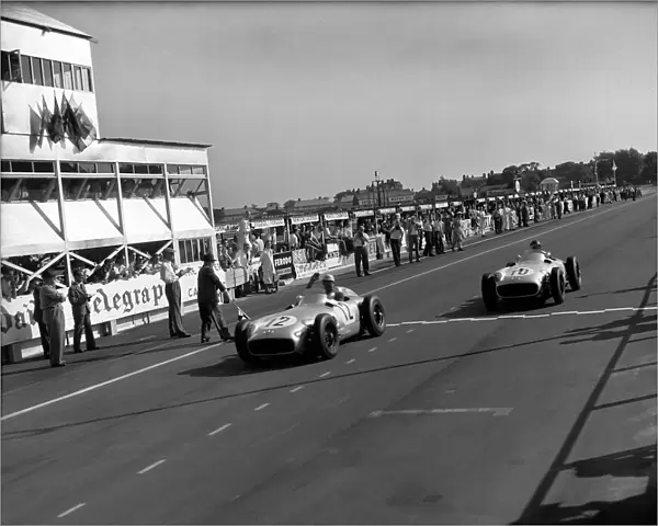 1955 British Grand Prix: Stirling Moss leads Juan Manuel Fangio in 1st and 2nd positions respectively at the finish, action