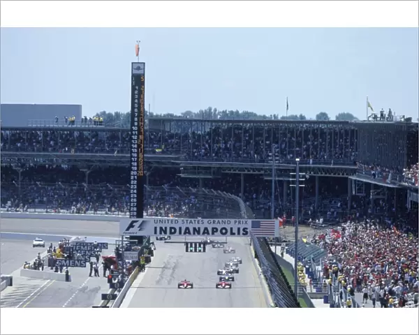 Indianapolis, USA. 18th - 19th June: The two Ferraris lead the field down to the first corner after the re-start