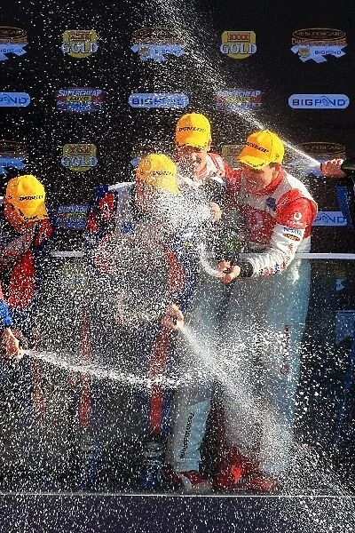 08av811: Craig Lowndes and Jamie Whincup Team Vodafone 888 Ford, who won their third straight Bathurst 1000, spray the champagne at the podium