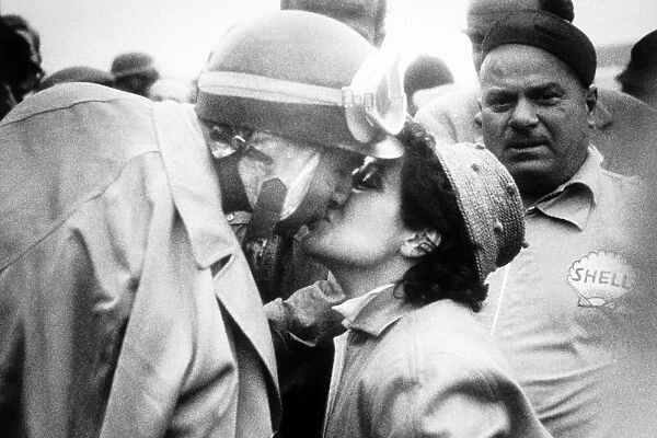 1956 British Grand Prix: Juan Manuel Fangio, Lancia-Ferrari D50, 1st position, kisses his wife after victory, portrait, helmet, podium
