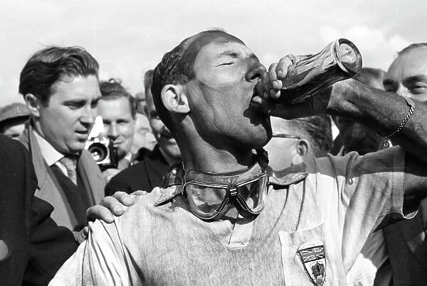 1957 British Grand Prix: Stirling Moss takes a victory drink of Coca-Cola after he and Tony Brooks won the first World Championship Grand Prix