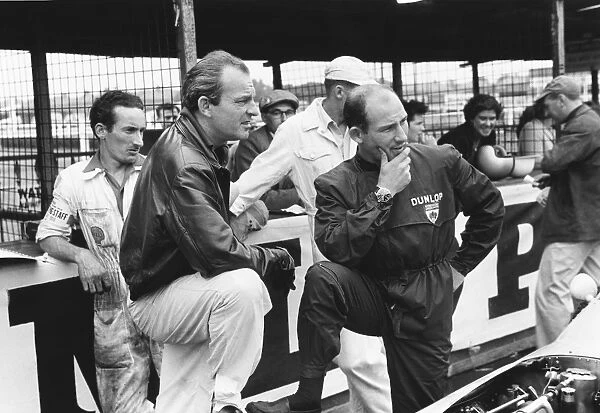 1959 British Grand Prix: Stirling Moss, 2nd position and Harry Schell, 4th position, chat in the pits, portrait