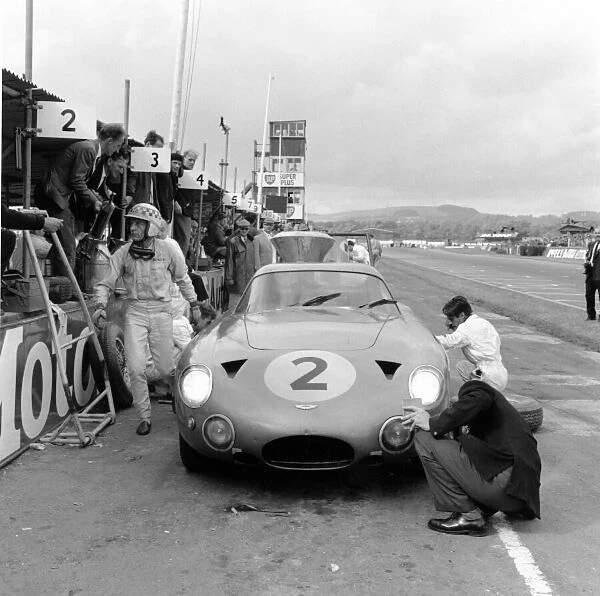 1963 Tourist Trophy. Goodwood, Great Britain. 24 August 1963. World Sports Car Championship. Innes Ireland, Aston Martin pit stop, action. Ref: 20988. World Copyright: LAT Photographic
