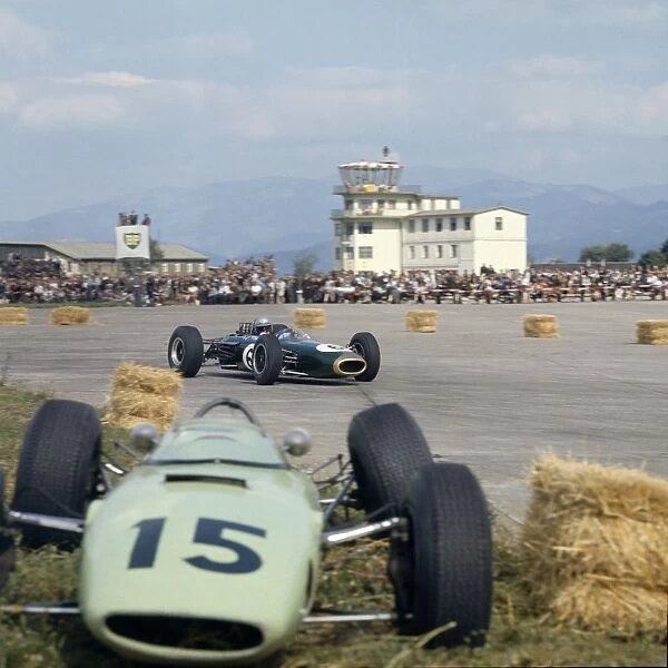 1964 Austrian Grand Prix: Jack Brabham passes the crashed car of Trevor Taylor