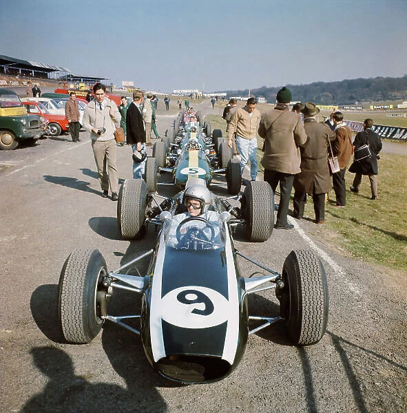 1965 Race of Champions. Brands Hatch, England. 13th March 1965. Bruce McLaren (Cooper T77-Climax), 12th position, sits in his car in front of Jim Clark (Lotus 33-Climax), 1st position, before the start of the race, portrait