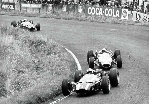 1966 German Grand Prix. Nurburgring, Germany. 7 August 1966. John Surtees, Cooper T81-Maserati, 2nd position, leads Jack Brabham, Brabham BT19-Repco, 1st position, and Jochen Rindt, Cooper T81-Maserati, 3rd position