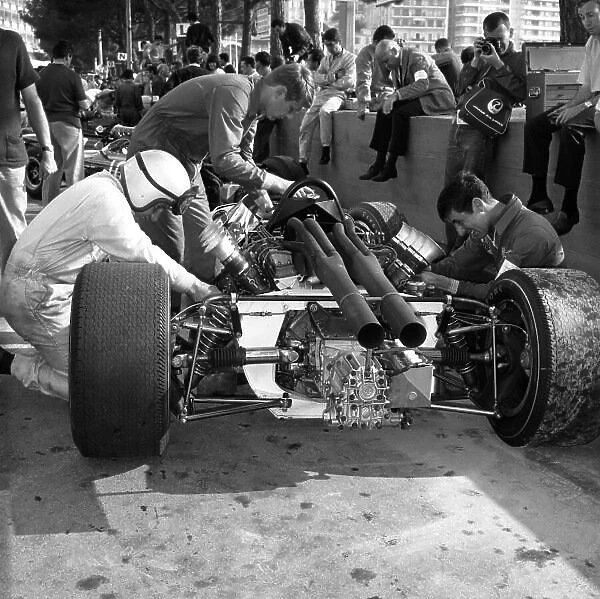 1966 Monaco Grand Prix. Monte Carlo, Monaco. 19th - 22nd May 1966. Bruce McLaren (McLaren M2B Ford), retired. This was the team's debut Grand Prix, Tyler Alexander works on the car behind Bruce, portrait. World Copyright: LAT Photographic