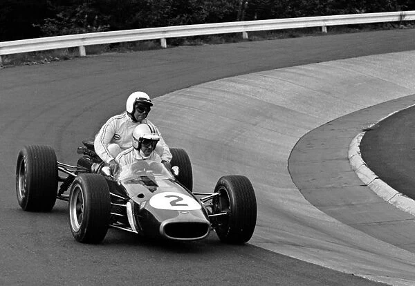 1967 GERMAN GP: Denny Hulme gives a lift to Jack Brabham at the Nurburgring. The two driver scame 1st and 2nd in the race