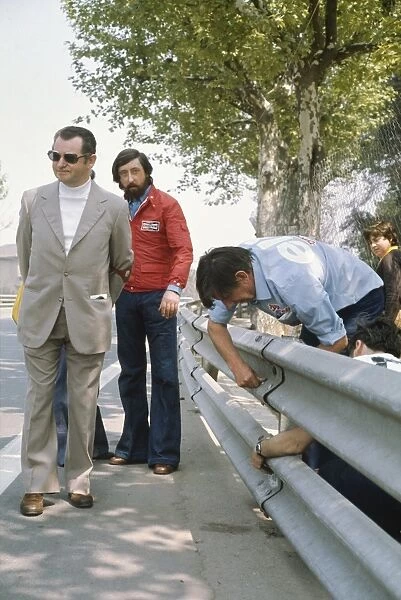 1975 Spanish Grand Prix - Ken Tyrrell: Ken Tyrrell examines the armco barriers, which were the subject of concern causing a driver protest