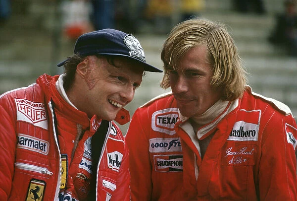 1977 Belgian Grand Prix: Niki Lauda, 2nd position, shares a joke with James Hunt, 7th position, in the pits, portrait