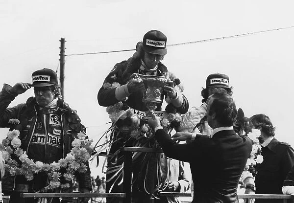 1977 British Grand Prix: James Hunt, 1st position, receives his winners trophy from HRH Prince Michael of Kent with Niki Lauda, 2nd position