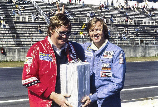 1977 Japanese Grand Prix. Fuji, Shizuoka, Japan. 21 - 23 October 1977. Alan Henry presents Ronnie Peterson with a carriage clock at the circuit, portrait. World Copyright: LAT Photographic