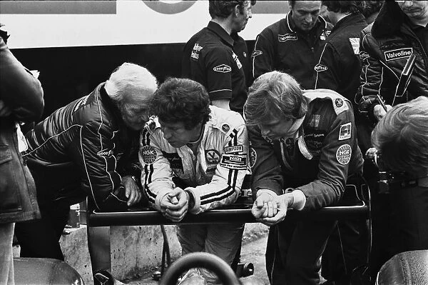 1978 British Grand Prix: Mario Andretti and Ronnie Peterson chat with team boss Colin Chapman i9n the pits, portrait