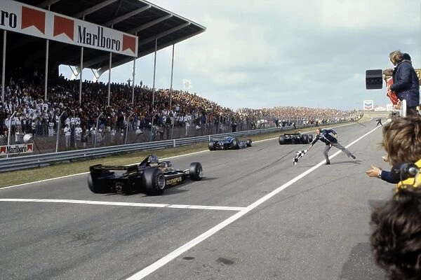 1978 Dutch Grand Prix - Finish: Mario Andretti, 1st position, leads Ronnie Peterson, 2nd position, across the finish line with Colin Chapman