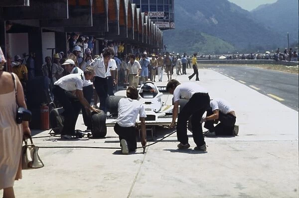 1979 Brazilian Grand Prix: Alan Jones, retired, in the pits with Ross Brawn looking on, action