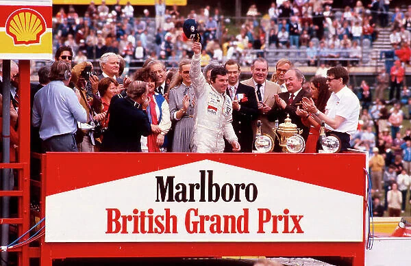 1980 British Grand Prix. Brands Hatch, England. 11-13 July 1980. Alan Jones (Williams Ford) 1st position celebrates on the podium. Ref-80 GB 22. World Copyright - LAT Photographic