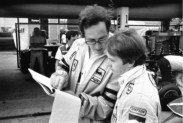 1980 German Grand Prix: Gilles Villeneuve with team director Mauro Forghieri in the pits, portrait