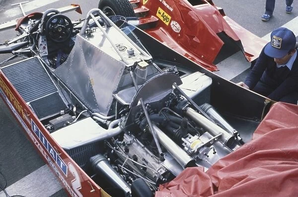 1981 United States Grand Prix West: Gilles Villeneuve, retired, turbo engine uncovered in the pits, action
