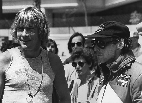 1982 Canadian Grand Prix: Lames Hunt in converstion with Niki Lauda in the pits, portrait
