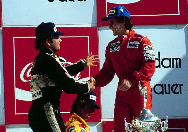 1984 BRAZILIAN GP. Elio de Angelis congratulates race winner Alain Prost on the podium