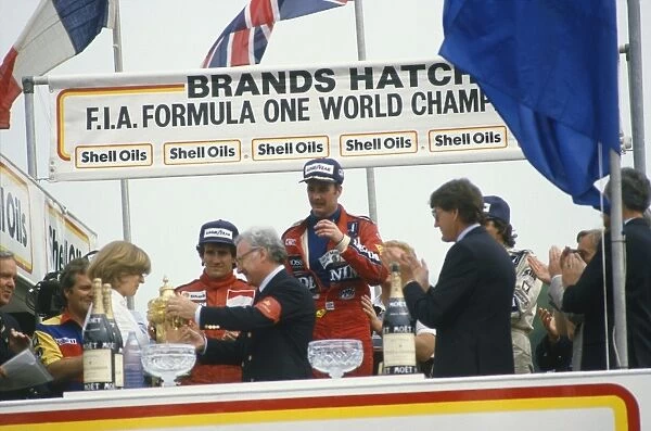 1986 British Grand Prix: Nigel Mansell 1st position, Nelson Piquet 2nd position and Alain Prost 3rd position on the podium, with Mrs Virgina