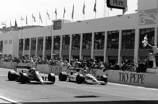 1986 Spanish Grand Prix. Jerez, Spain. 13 April 1986. Ayrton Senna, Lotus 98T-Renault, 1st position, (left) and Nigel Mansell, Williams FW11-Honda, 2nd position, at the finish, action. World Copyright: LAT Photographic