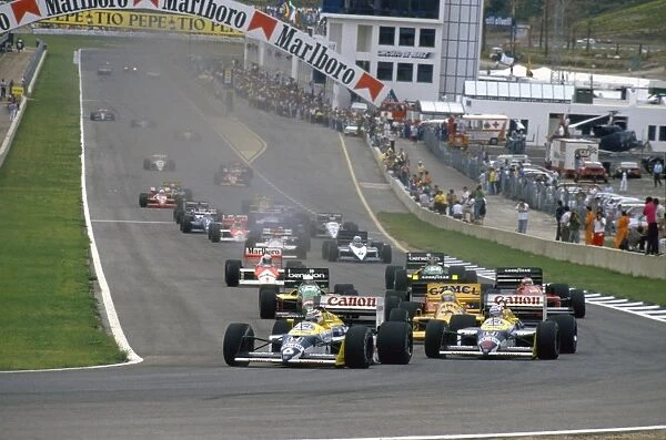 1987 Spanish Grand Prix: Nelson Piquet and teammate Nigel Mansell lead Ayrton Senna into Curva Expo at the start