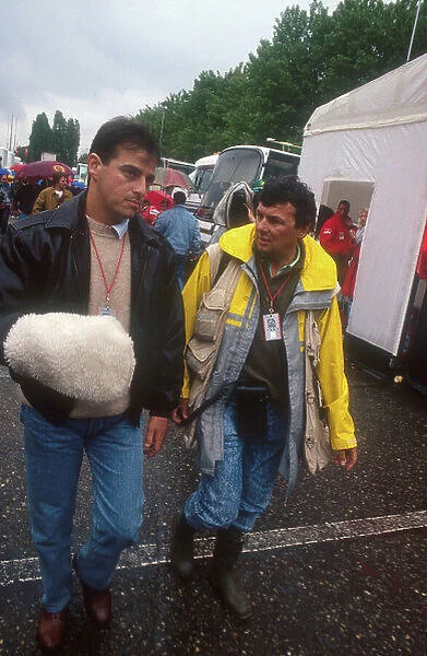 1991 San Marino Grand Prix.Imola, Italy.26-28 April 1991.Alessandro Nannini with photographer, Ercole Colombo in the Imola paddock. The sheepskin glove protects his right hand which was severed in the helicopter crash last September