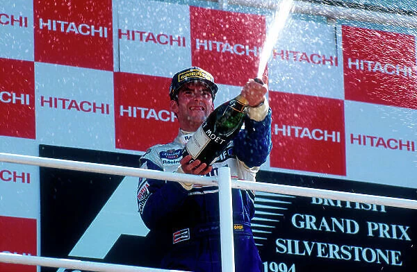 1994 British Grand Prix. Silverstone, England. 8-10 July 1994. Damon Hill (Williams Renault) 1st position, celebrates with the bubbly on the podium. Ref-94 GB 16. World Copyright - LAT Photographic