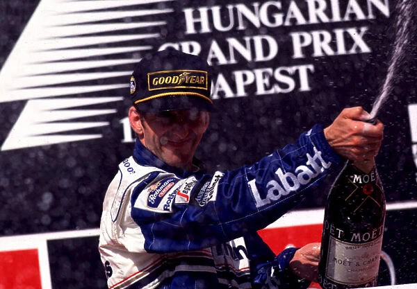 1995 HUNGARIAN GP. Damon Hill celebrates at the top of the podium after winning