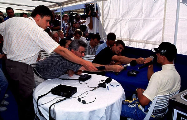 1995 HUNGARIAN GP. Michael Schumacher is invaded by microphones at the press