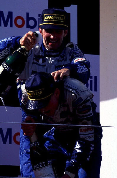 1995 PORTUGESE GP. David Coulthard celebrates on the podium with his Williams team